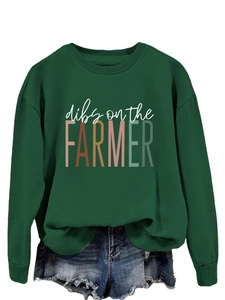 Detail of dark green sweatshirt featuring Dibs On The Farmer colorful graphic print