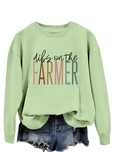 Detail view of light green crewneck sweatshirt with dibs on the farmer print text