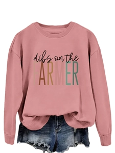 Flat lay of pink crewneck sweatshirt with 'dibs on the FARMER' text and denim shorts
