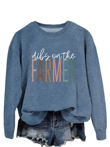 Detail of blue crewneck sweatshirt featuring 'dibs on the FARMER' text and soft fabric