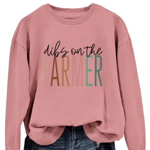 Pink crewneck sweatshirt with 'Dibs on the Farmer' text print paired with blue jeans