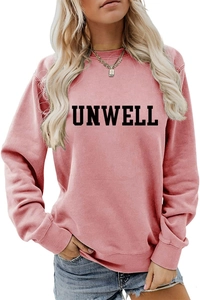 Detail of black UNWELL text print on a pink long-sleeved casual cotton sweatshirt