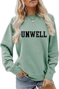 Detail of the sage green crewneck sweatshirt featuring a bold black UNWELL print design