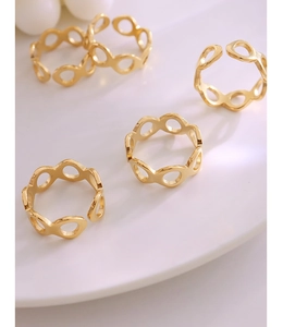 Vue macro de cinq bagues géométriques évidées ajustables en acier plaqué or 18 carats