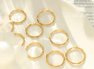 Close-up of 8-piece gold-plated textured ring set on a book background with natural light