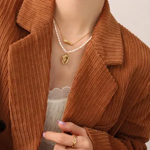 Mehrlagige Goldkette mit Perlenhalskette und Porträt-Anhänger am Model