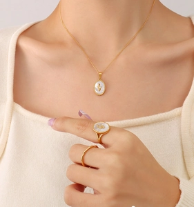 Dettaglio di anello e collana vintage con intarsio in conchiglia a tulipano su modella