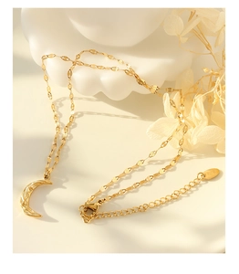 Detailed macro view of gold crescent moon pendant and K18 hallmark on the clasp chain
