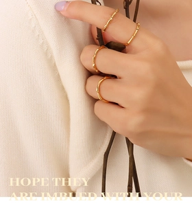 Detail of 18K gold plated bamboo joint stacking rings worn on female fingers