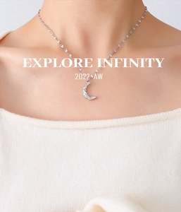 Detail of 18K gold plated crescent moon pendant necklace worn on model neck