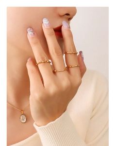Detail of 18K gold plated chain rings and oval cactus shell pendant on a model