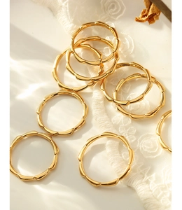 Detail of 18K gold plated titanium rings with a wavy bamboo design on lace fabric