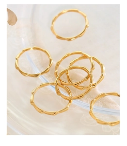Macro detail of 18K gold plated bamboo link rings showing polished metal texture