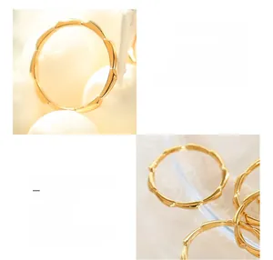 Macro detail of wave-shaped 18K gold plated titanium steel rings with polished finish