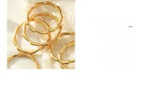 Close-up of wavy minimalist gold rings on white lace with natural sunlight shadows