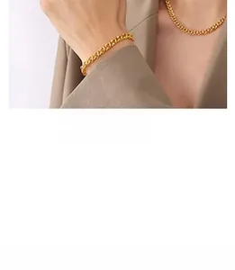 Détail d'un ensemble collier et bracelet à mailles gourmettes dorées sur un mannequin