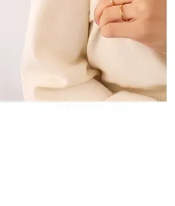 Gros plan d'une bague dorée réglable avec texture tissée portée sur le doigt