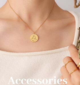 Détail du collier doré avec pendentif visage abstrait et bagues minimalistes assorties
