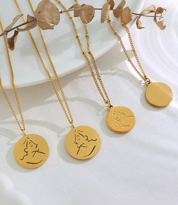 Vue détaillée de pendentifs ronds dorés avec portraits minimalistes sur de fines chaînes