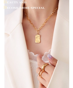 Collier à pendentif portrait abstrait et ensemble de bagues dorées sur un mannequin