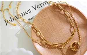Détail du collier double couche en or 18 carats avec pendentif à trois anneaux