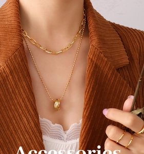 Détail d'un collier doré à double rangée avec maillons trombones et pendentif anneaux