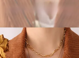 Gros plan d'un ensemble de colliers dorés à deux couches sur un mannequin en velours