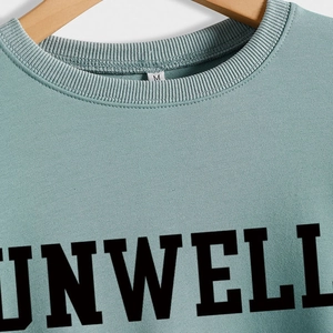 Light blue sweatshirt with black UNWELL letter print and ribbed crewneck design