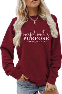Detail of white inspirational letter print on burgundy crewneck long sleeve sweatshirt