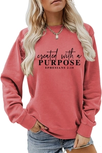 Close-up of rust red crewneck sweatshirt featuring created with a purpose letter print