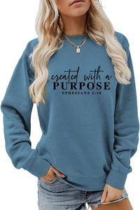 Close-up of 'created with a PURPOSE' text and Ephesians 2:10 print on slate blue sweatshirt