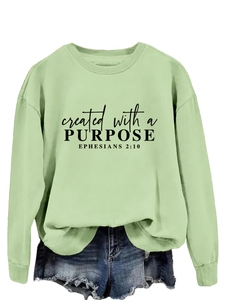Detail of mint green crewneck sweatshirt showing black lettering and soft cotton texture
