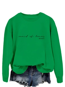Detail of green Maid of Honor sweatshirt with black text and denim shorts