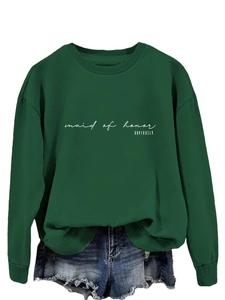 Detail of dark green crewneck sweatshirt featuring white Maid of Honor text and denim shorts
