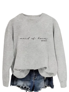 Detail of grey crewneck sweatshirt with black 'maid of honor' text and denim shorts