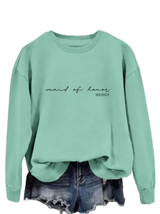 Detail of mint green sweatshirt featuring black 'maid of honor' slogan print text