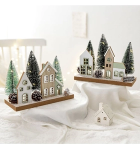 Detalle de aldea navideña de madera nórdica con casitas en miniatura y luces LED cálidas