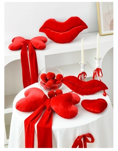 Close-up of red velvet lip-shaped pillows and decorative bows for romantic party decor