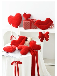 Red velvet Valentine decorations featuring heart cushions and giant bow in home setting