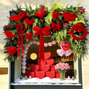 Red flocked heart and lip ornaments hanging in a romantic Valentine window display