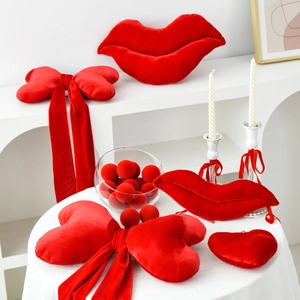 Red velvet Valentine decorations featuring lip-shaped pillows and a large ribbon bow
