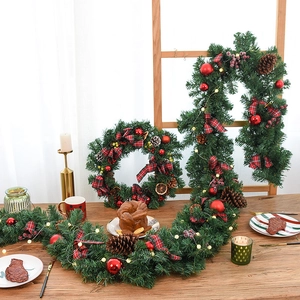 2.7m Christmas garland with red ornaments, plaid bows and pine cones on a dining table