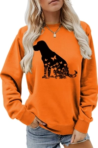 Détail d'un sweat orange avec une silhouette de chien noire et motifs floraux