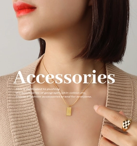 Detail of 18K gold plated snake chain with square Love pendant and heart ring on model