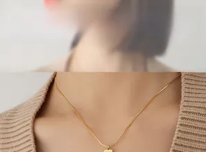 Close-up of minimalist 18K gold plated snake chain necklace with square pendant on neck