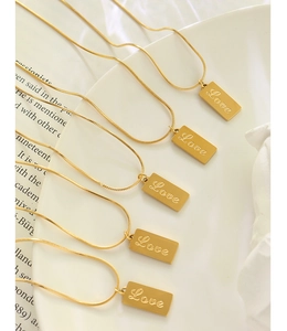 Detail of 18K gold-plated snake bone chain with engraved Love rectangular pendant