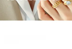 Gros plan d'une main portant une bague chaîne cubaine plaquée or 18K et une bague cœur