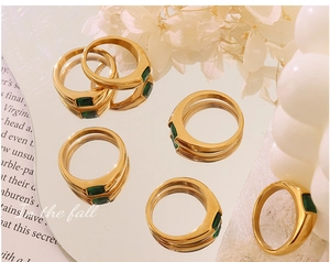 Artistic detail of 18K gold plated rings with emerald cut green zircon stones