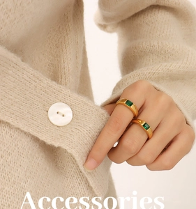 Detail of 18K gold plated rings with emerald green zircon stones on model's hand