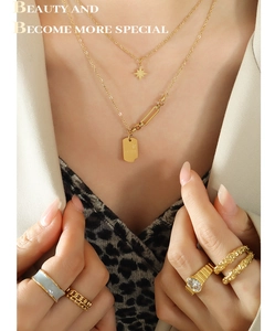 Détail du collier double rang plaqué or 18K avec pendentifs étoile et carré et bagues